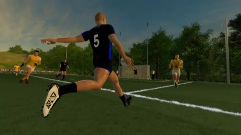 In game footage of a Gaelic Football player kicking the ball towards goal. He is wearing a black and blue jersey, sporting black shorts and white football boots.