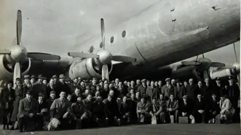 South Wales Police Heritage Museum A group of people with cases photographed in front of the Avro Tudor aircraft before it set off for Ireland.