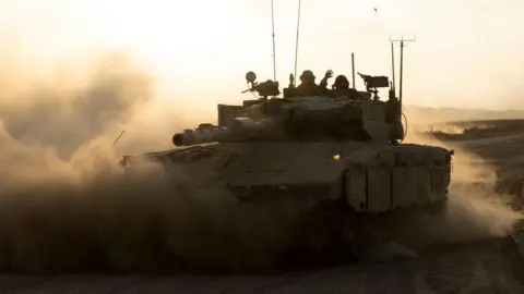 Getty Images Israeli soldiers in a tank driving along the border with the Gaza Strip in southern Israel