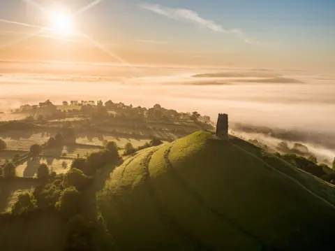 Glastonbury Tor seen from above with mist in the valley below