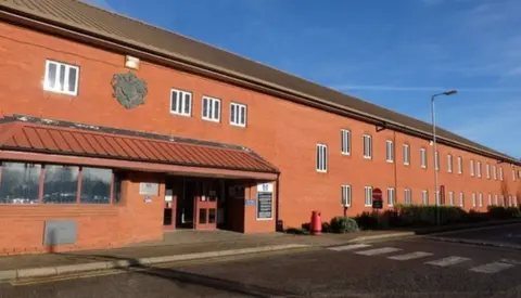 Exterior of the Mount prison, showing a long, red brick building 