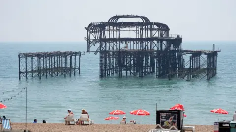 The metal shell of a derelict Victorian pier out at sea. 