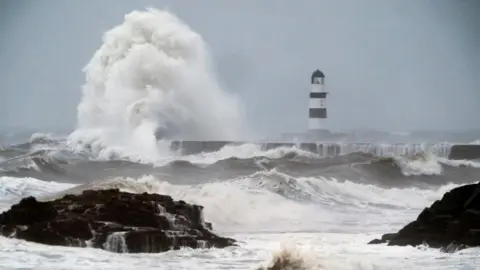 PA Waves crash against the lighthouse in Seaham Harbour, County Durham.