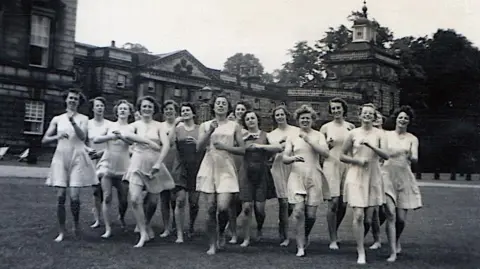 Lady Mabel College Archive Collection A historic photo of Lady Mabel College, depicting a group of women jogging across the grounds of the Georgian-era stately home, Wentworth Woodhouse. 