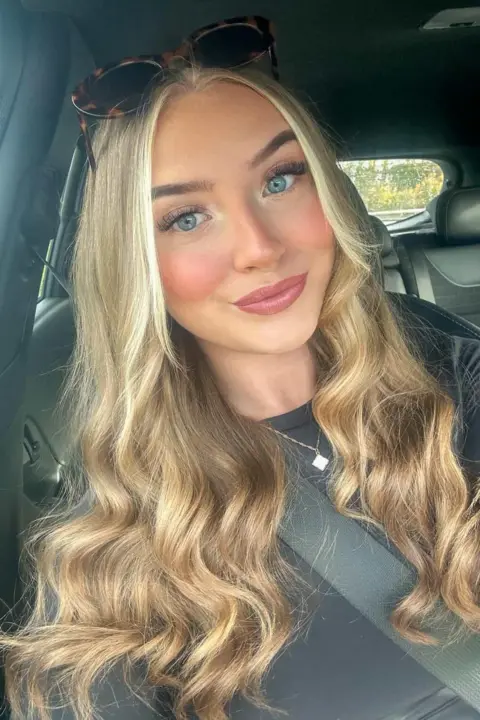 Lily-May Edwards A selfie of Lily-May without her glasses. She wear dark sunglasses on top of her head. She has blue eyes and pink lipstick