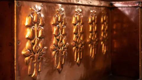 Andy Marshall A close-up of the copper work showing a row of fleur de lys stylised engravings 