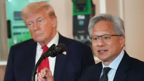 Getty Images US President Donald Trump (L) listens as Nvidia CEO Jensen Huang speaks to an audience through a microphone in front of him 