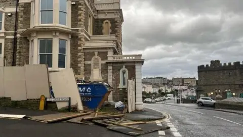 PA Media Damaged boarding around a property in Clevedon