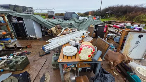 Johnny Rutherford/BBC A general view of the Noon Cregg CIC Veterans Retreat showing tents blown over and belongings strewn all over the ground.