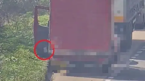 Buckinghamshire Council A red van parked in a layby behind a lorry. The passenger door of the van is open and litter is being thrown out of it.