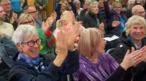 LDRS People cheering and clapping at a meeting.