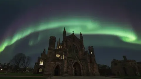 Ben Goulding A church building at night with wavy green blur behind it
