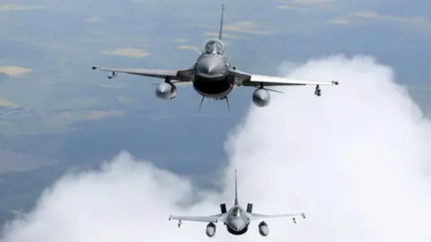 PETRAS MALUKAS / AFP Romanian Air Force F-16s military fighter jets participate in NATO's Baltic Air Policing Mission in Lithuanian airspace near Siauliai, on May 23, 2023