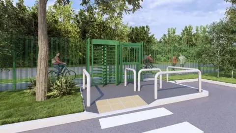 A secure green turnstile gate blocks entry to a fenced path, with white metal barriers and tactile paving in front, while several cyclists ride along the tree‑lined route behind it.
