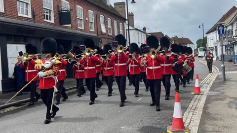 A general view of the Band of the Coldstream Guards marching and playing through Thatcham town centre.