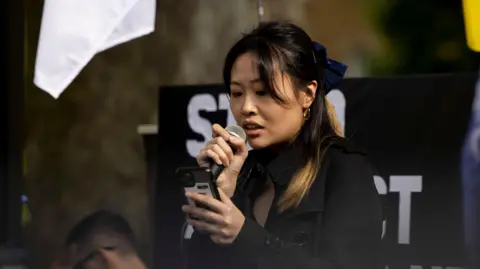 Getty Images Carmen Lau, activist in exile and former Pro-democratic District Councilor of Hong Kong, seen making speeches during the rally outside Downing Street in 2022.