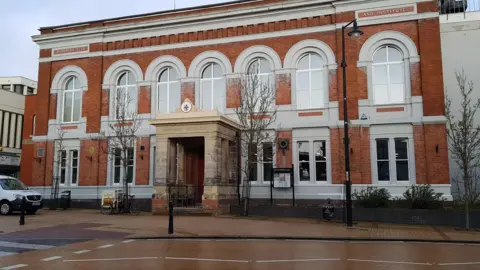 BBC The outside of a two-storey building with arched windows and a pillared entrance.