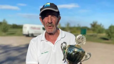 Lake Snakes Angling Club Ian Coates holding a fishing trophy 