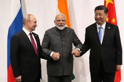  (RUSSIA OUT) Russian President Vladimir Putin (L), Indian Prime Minister Narendra Modi (C) and Chinese President Xi Jinping (R) pose for a group photo prior to their trilateral meeting at the G20 Osaka Summit 2019 on June 28, 2019 in Osaka, Japan. Vladimir Putin has arrived in Japan to participate in the G20 Osaka Summit and to meet U.S.President Donald Trump. (Photo by Mikhail Svetlov/Getty Images)