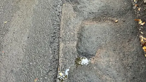 Paul Hughes The potholed section of Sugar Loaf Lane 