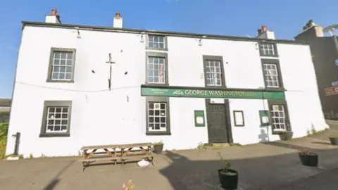 Google A large whitewashed walled pub building with the name George Washington on the green-and-gold sign.