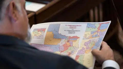 Getty Images State Representative Matt Morgan, seen from behind, reviews a coloured map of proposed congressional redistricting during a special session at the Texas State Capitol in Austin, Texas, US