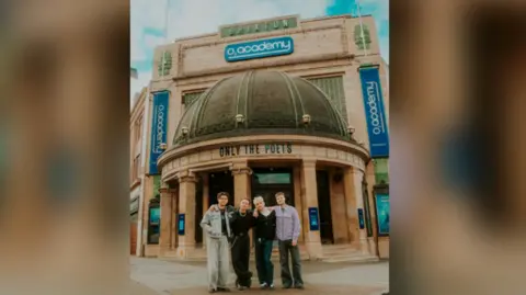 Jordan Logan Only the Poets standing outside the O2 Academy Brixton in London, with "Only the Poets" templated in black capital letters on the dome outside it.