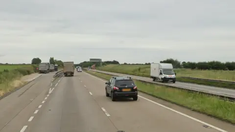 Google Cars and lorries travelling along a dual carriageway in both directions