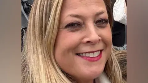 Close-up of Annabel Rook smiling at the camera. She had blonde hair and red lipstick.