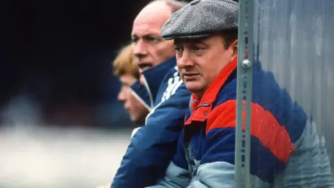 Getty Images Graham Carr in 1987, wearing a flatcap