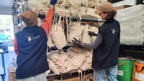 BABY BASICS Baby Basics Sheffield volunteers loading supplies on to a set of shelves.