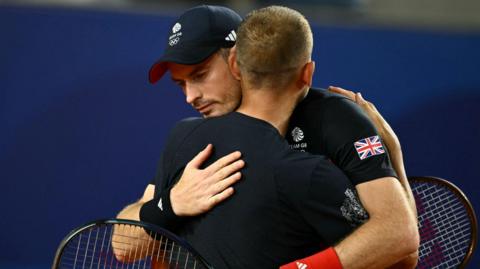 Andy Murray and Dan Evans embrace after the Scot's final match of his career