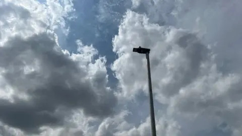 A street light in Devon with clouds and sky behind