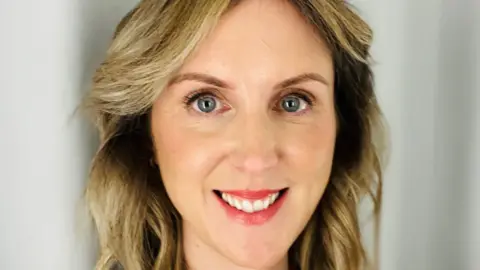 Louise Bramble A headshot of a lady with shoulder length, wavy, blonde hair. She is smiling into the camera and has blue eyes. 