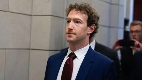 Getty Images Mark Zuckerberg, CEO of Meta, wearing a dark blue suit with a dark red tie