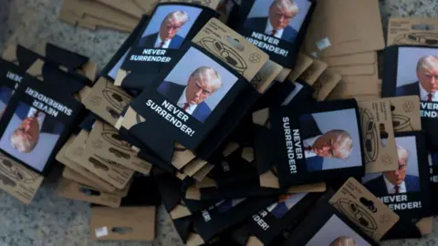 Getty Images An image of Donald Trump's jail mugshot on a stubby holder