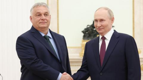 Russian President Vladimir Putin (R) shakes hands with Hungarian Prime Minister Viktor Orban (L) during a meeting at the Kremlin, in Moscow, Russia, 05 July 2024. The pair are both wearing dark suits and shaking hands, with slight smiles.