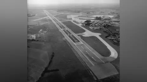 Manchester Airport Black and white photograph of Manchester Airport with only one runway