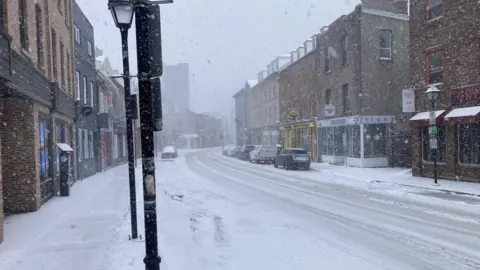 Jon Shipman A street in Newfoundland covered in snow. Cars can be seen on either side of the street. 