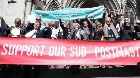 Former station  bureau   workers observe  with raised fists and a ample  reddish  banner that says 'support our sub-postmasters' extracurricular  the Royal Courts of Justice, London, aft  having their convictions overturned by the Court of Appeal successful  April 2021