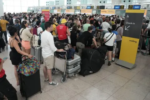 EPA Passengers wait to check in at Josep Tarradellas Barcelona-El Prat Airport, in Barcelona