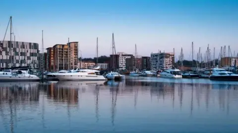 Getty Images A harbour filled with boats. Behind the boats you can see the buildings