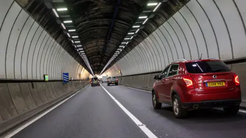 Huw Fairclough/Getty Images One of the two Brynglas Tunnels in Newport, with cars in both carriageways. A red car is closest to the camera on the right hand side.