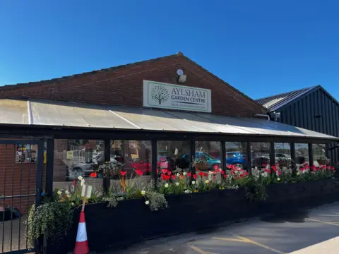 The entrance to Aylsham Garden Centre is lined by planter boxes with colourful plants growing inside them