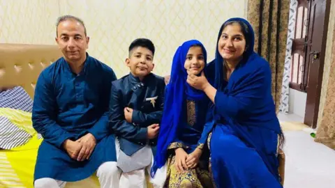 Maria Khan The twins seen sitting with their parents Urusa and Rameez Khan in a room.