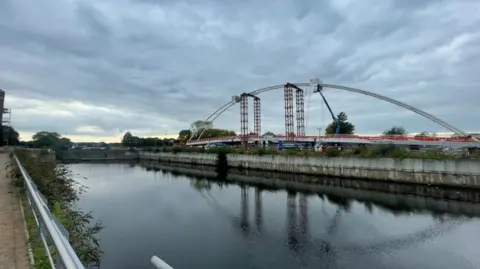 A view of the Trent Basin waterway, with the Waterside Bridge dominating the skyline in the background.