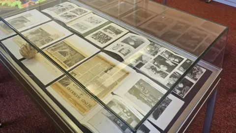 Wolverhampton Archives A glass display case with a variety of photographs and newspaper clippings inside