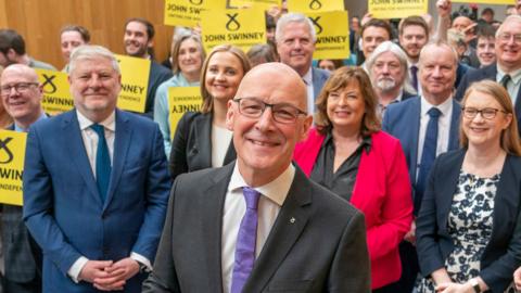 John Swinney in front of SNP MSP's and members