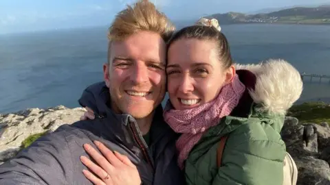 Handout A selfie of Mick Thurston and Vicky Green embracing while out on a walk near the sea. Ms Green is wearing an engagement ring. Both are smiling.