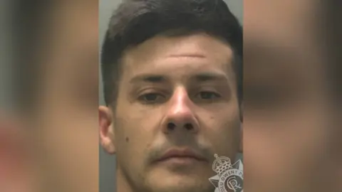 Gwent Police Mugshot of Owen Pendree. He is clean shaven and has short dark hair. 